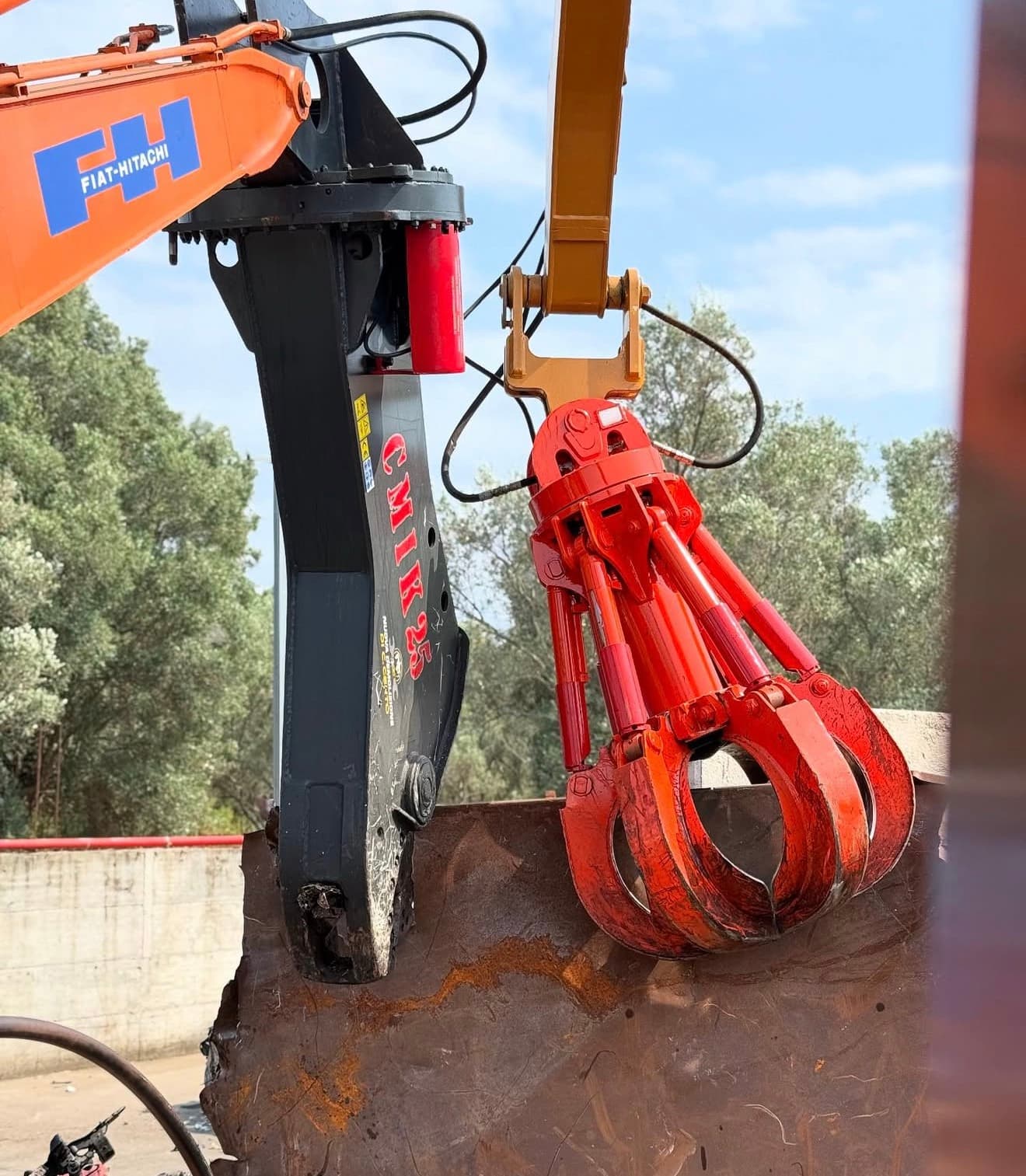 Cesoia e polipo montati sui bracci dei ragni per la lavorazione dei rottami